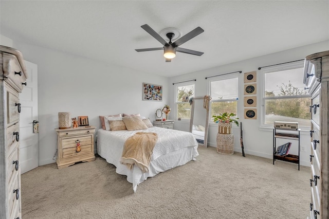 bedroom with light carpet, ceiling fan, and baseboards