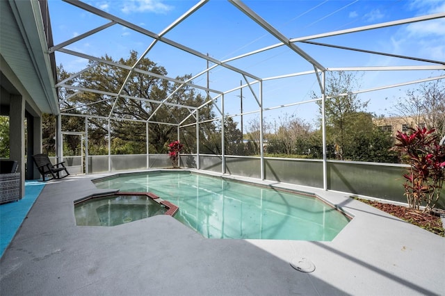 view of swimming pool with a patio area, glass enclosure, and a pool with connected hot tub