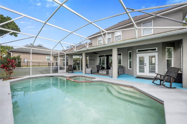 view of swimming pool with french doors, a patio, a ceiling fan, a lanai, and an outdoor living space