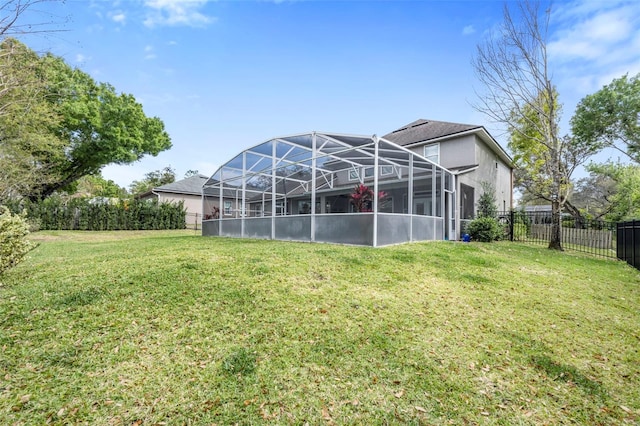 rear view of property featuring a yard, a fenced backyard, and a lanai