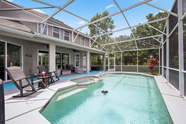 view of pool with ceiling fan, a patio, glass enclosure, and a pool with connected hot tub