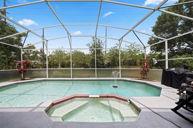 view of swimming pool featuring glass enclosure, a pool with connected hot tub, a grill, and a patio