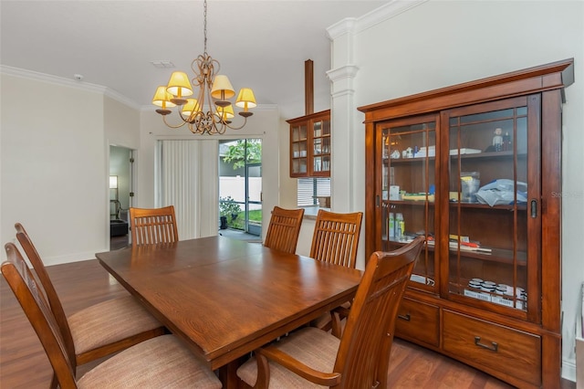 dining room featuring ornamental molding, baseboards, an inviting chandelier, and wood finished floors