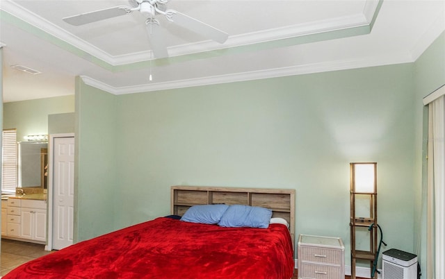 bedroom with light tile patterned floors, a tray ceiling, visible vents, and crown molding