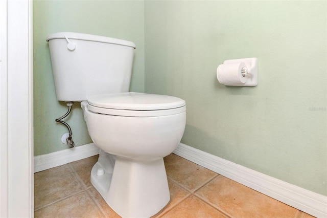 bathroom featuring tile patterned flooring, toilet, and baseboards