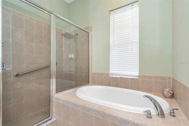 bathroom featuring a stall shower and a bath