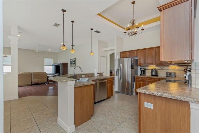 kitchen featuring appliances with stainless steel finishes, a sink, hanging light fixtures, and light tile patterned floors