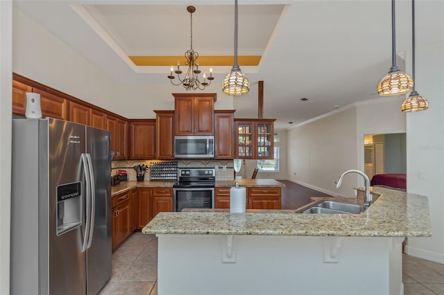 kitchen with stainless steel appliances, pendant lighting, a sink, and a kitchen breakfast bar