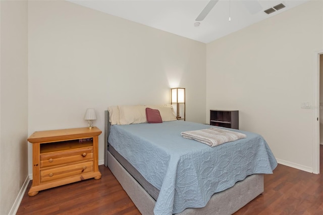 bedroom with dark wood-type flooring, a ceiling fan, visible vents, and baseboards