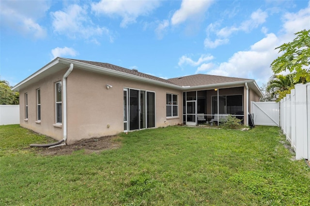 back of property featuring a sunroom, a fenced backyard, and a yard