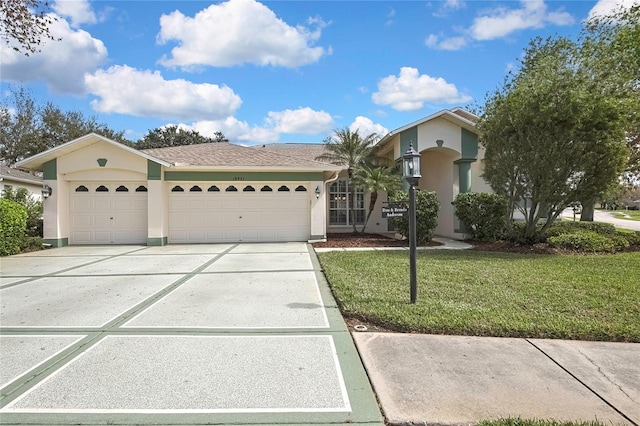 view of front of home with roof with shingles, stucco siding, concrete driveway, an attached garage, and a front yard