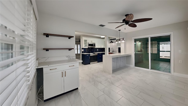 kitchen with decorative backsplash, white cabinets, hanging light fixtures, stainless steel appliances, and open shelves