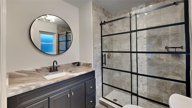 full bath featuring toilet, a shower stall, and vanity