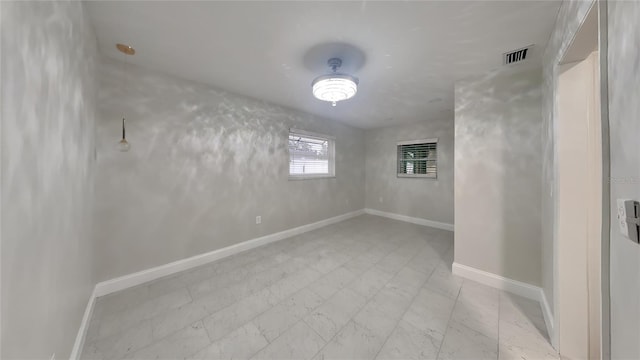 basement with light floors, baseboards, and visible vents