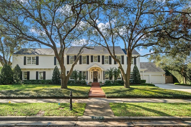 view of front of home with a garage, concrete driveway, and a front yard