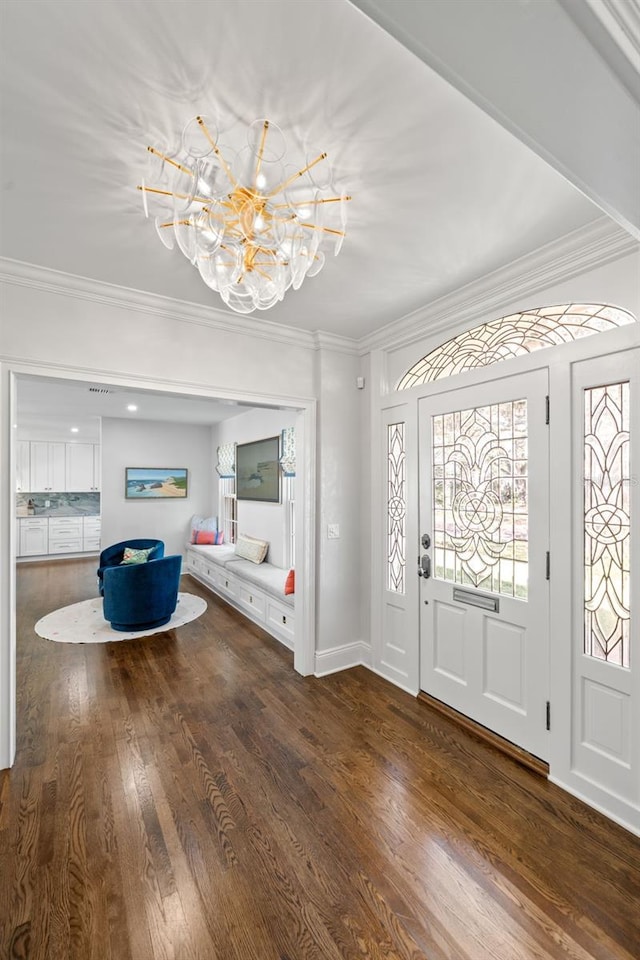 entryway with baseboards, a notable chandelier, crown molding, and hardwood / wood-style floors