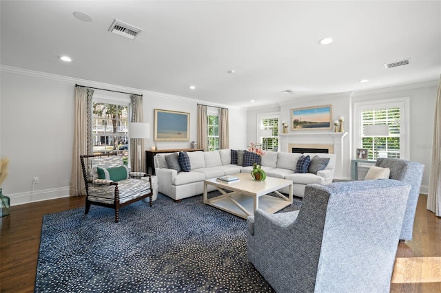 living area featuring visible vents, crown molding, and wood finished floors