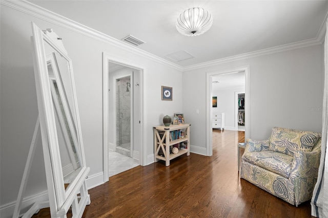 sitting room featuring attic access, baseboards, visible vents, wood finished floors, and crown molding