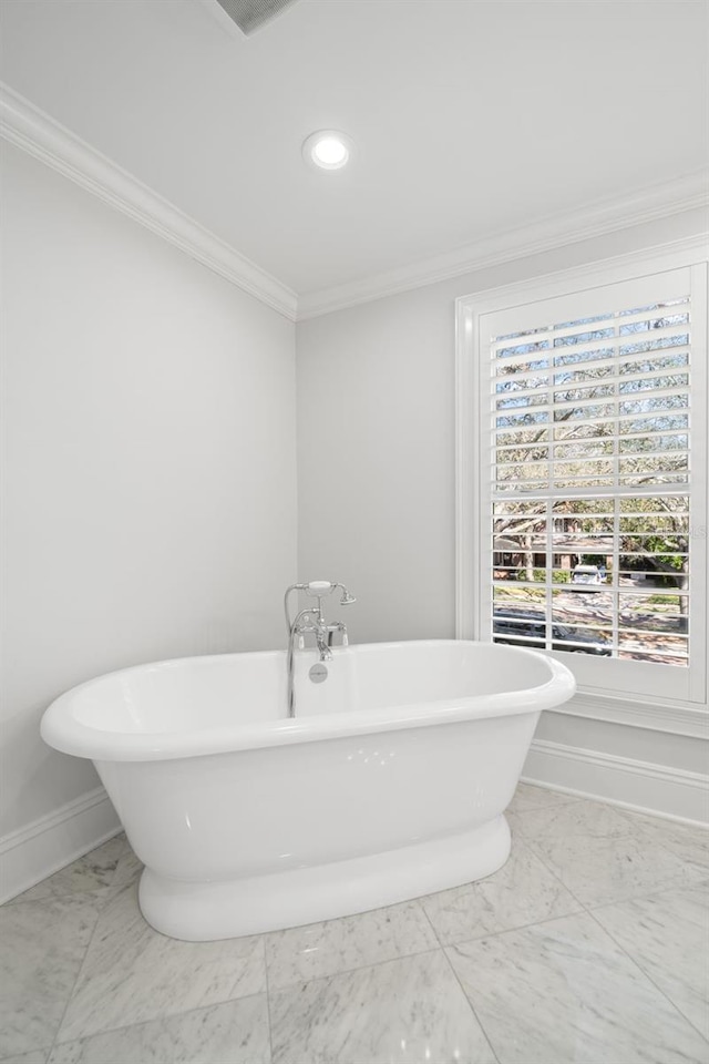 bathroom featuring recessed lighting, baseboards, a freestanding bath, marble finish floor, and crown molding