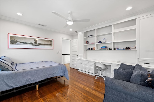 bedroom with dark wood-style flooring, built in desk, recessed lighting, visible vents, and ornamental molding