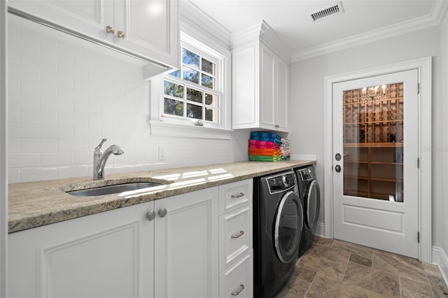 laundry area with cabinet space, visible vents, washing machine and clothes dryer, crown molding, and a sink