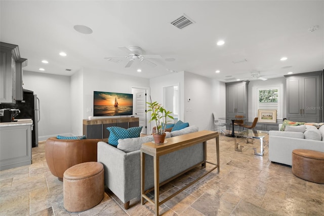 living room with a ceiling fan, recessed lighting, stone tile flooring, and visible vents