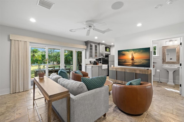 living room with stone tile floors, recessed lighting, visible vents, ceiling fan, and baseboards