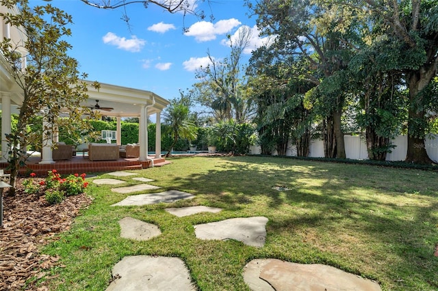 view of yard with a fenced backyard, ceiling fan, and outdoor lounge area