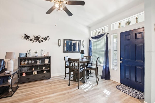 dining area with a ceiling fan, lofted ceiling, baseboards, and wood finished floors