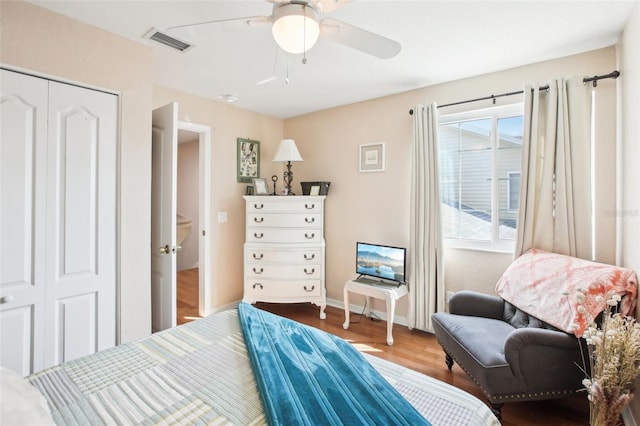 bedroom featuring baseboards, visible vents, ceiling fan, wood finished floors, and a closet