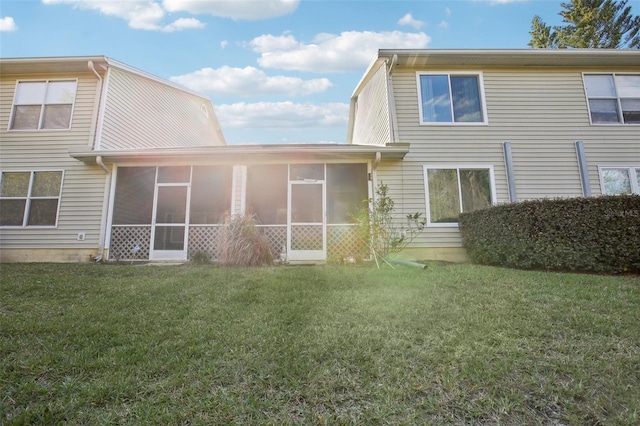 rear view of house with a sunroom and a yard