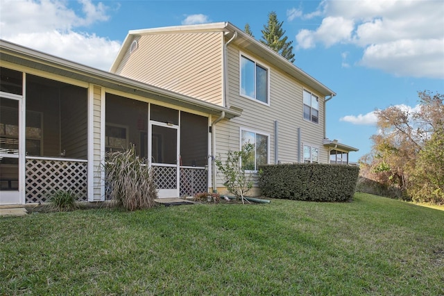 back of property with a yard and a sunroom