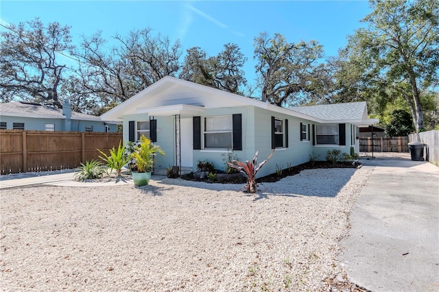 view of front facade with concrete driveway and fence