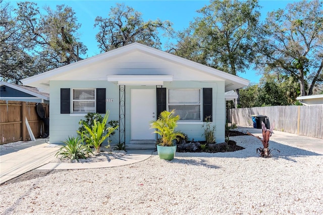 bungalow featuring driveway and fence