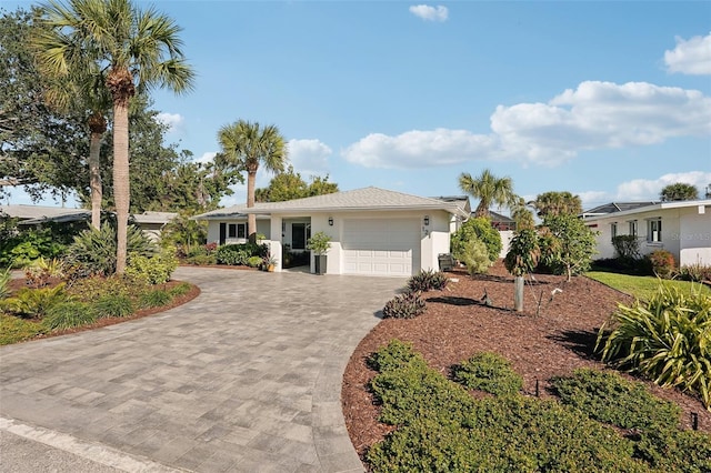 single story home with a garage, decorative driveway, and stucco siding