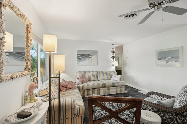 living area with a ceiling fan, visible vents, and baseboards