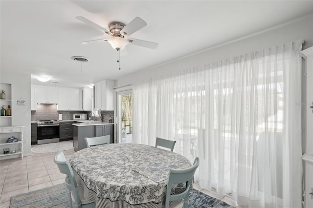 dining space featuring ceiling fan, visible vents, and light tile patterned flooring