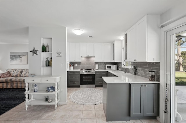 kitchen with electric range, white cabinets, white microwave, gray cabinetry, and a sink