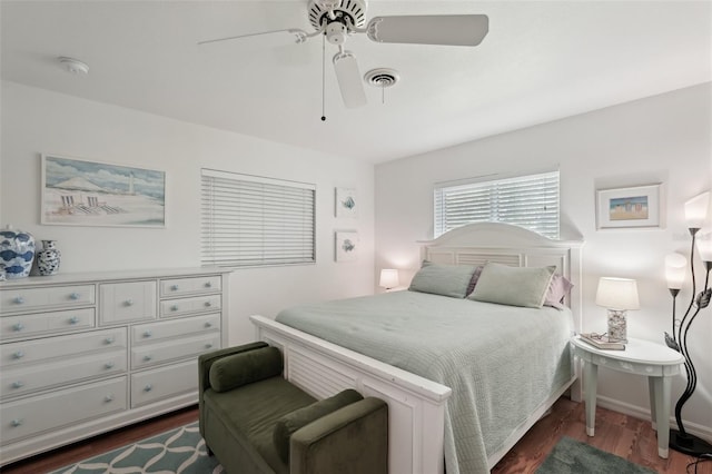 bedroom with dark wood-type flooring, visible vents, baseboards, and a ceiling fan