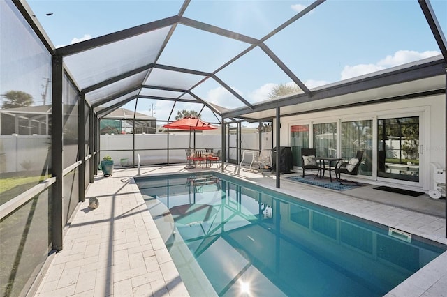 view of swimming pool with glass enclosure, fence, a fenced in pool, and a patio