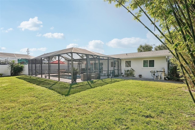 rear view of property with a lanai, a lawn, a patio, and stucco siding