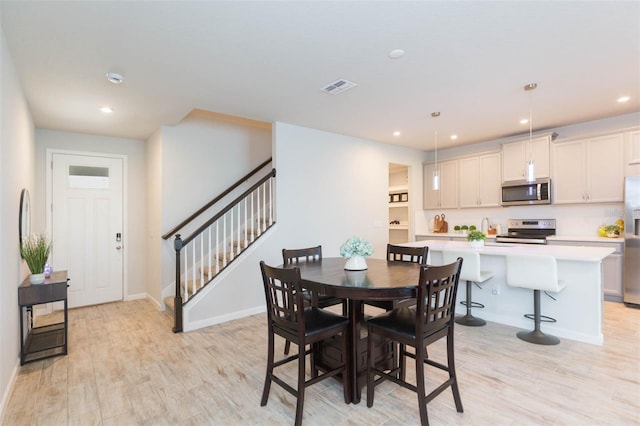 dining room featuring recessed lighting, visible vents, stairway, and light wood finished floors