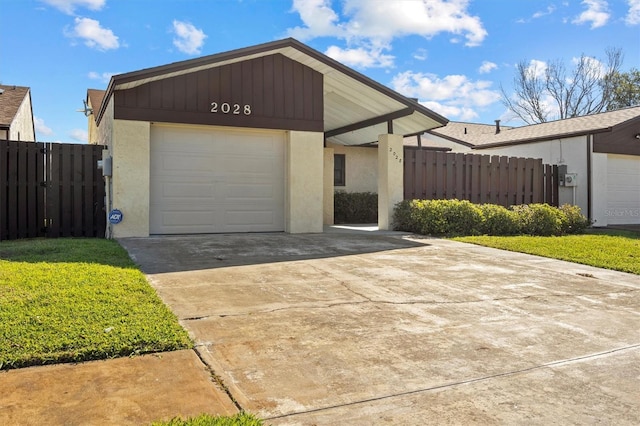 view of front of home with a garage, concrete driveway, fence, and stucco siding