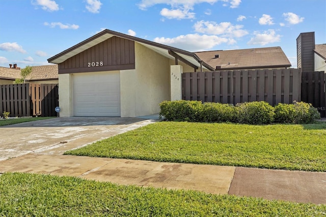 view of front of house featuring driveway, a front lawn, fence, and stucco siding