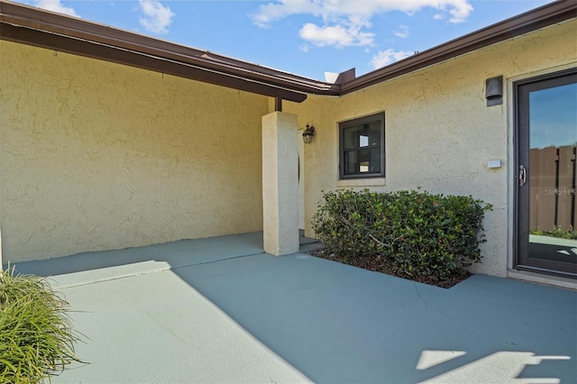 entrance to property with a patio and stucco siding