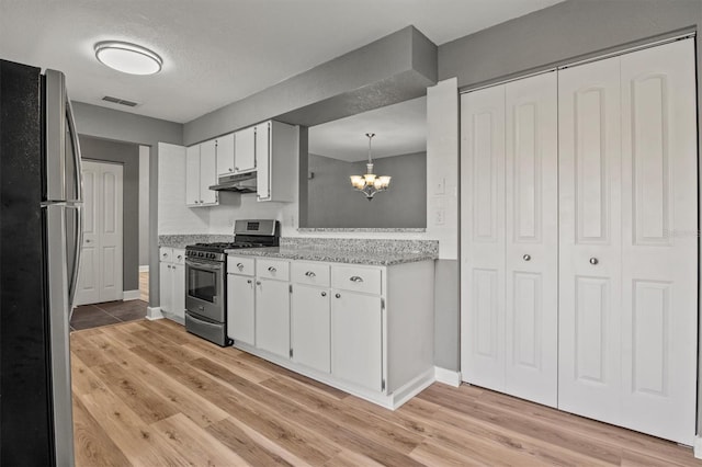 kitchen featuring a notable chandelier, under cabinet range hood, stainless steel appliances, white cabinetry, and visible vents