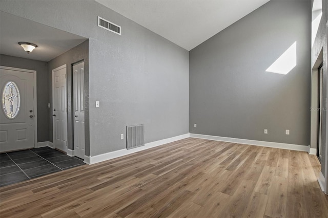 foyer featuring visible vents, baseboards, and wood finished floors