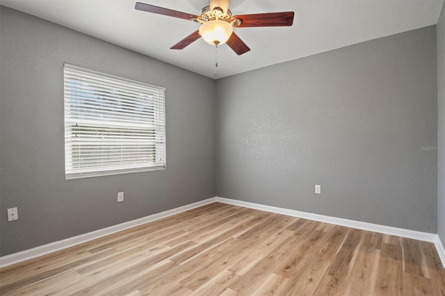 unfurnished room with light wood-style floors, baseboards, and a ceiling fan