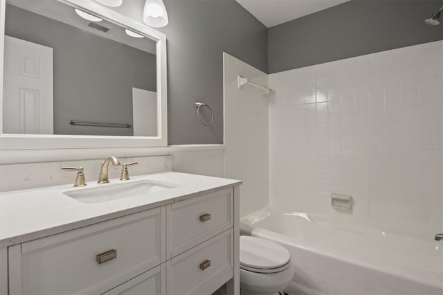 bathroom featuring visible vents, wainscoting, toilet, shower / tub combination, and vanity