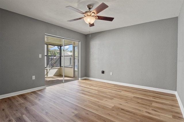 spare room with ceiling fan, baseboards, and wood finished floors